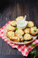 Zucchini stuffed with minced chicken and baked with cheese and herbs on a ceramic plate on a dark wooden background. Zucchini recipes.