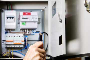 Removal outer jacket of high-voltage cable with retractable utility knife, against background of an...