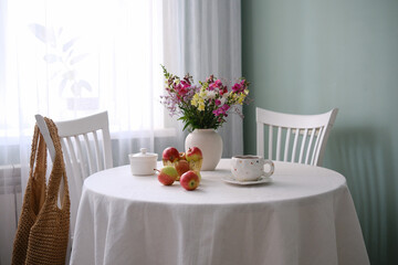 A Charming and Inviting Table Setting Featuring Bright Apples and Beautiful Fresh Flowers