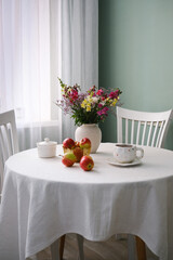 A Cozy Dining Table Beautifully Set with Fresh Fruits and Delightful Flowers to Enjoy