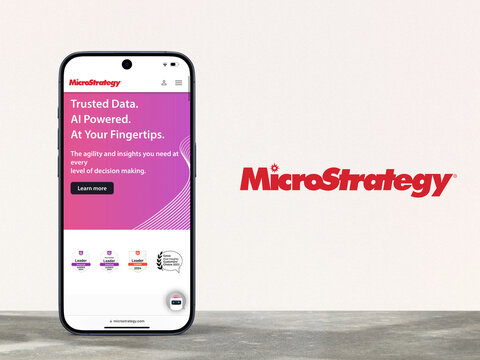 MicroStrategy website  is displayed on a modern smartphone, MicroStrategy logo next to it,  business intelligence, Bitcoin, data mining, ai, artifical intelligence, solutions, software