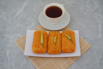 Chicken risoles  and hot tea on bamboo mat background.