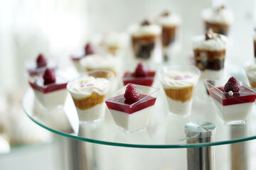 A sweet dessert table of mousses decorated with berries.