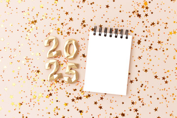 2025 New Year concept with copy space. Empty notepad mockup, shiny stars confetti and golden...