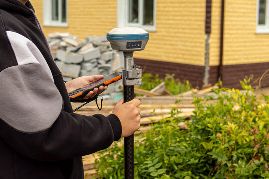 Cadastral engineer. Male worker brings out the points of the boundaries of land plot. Satellite technology. GPS geodesy