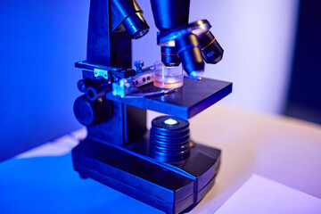 A laboratory sample under a microscope in a scientific and chemical laboratory. A person studies a dangerous sample