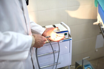 The proctologist checks the instrument before the procedure
