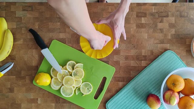 High angle view of woman hand making lemonade with lemon squeezer