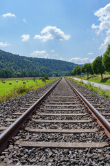 Fototapeta premium Landschaft mit Bahnschiene an einem Sommertag
