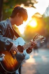 Obraz premium a young man playing an acoustic guitar in the street