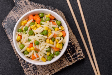 Delicious boiled rice with vegetables or risotto with carrots, peas and corn