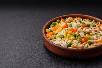 Delicious boiled rice with vegetables or risotto with carrots, peas and corn