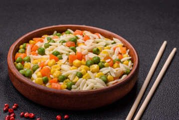 Delicious boiled rice with vegetables or risotto with carrots, peas and corn