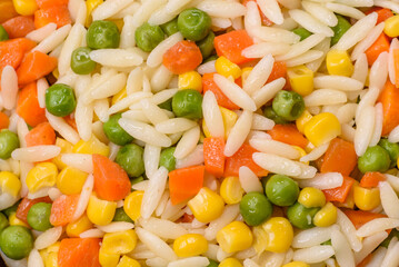 Delicious boiled rice with vegetables or risotto with carrots, peas and corn