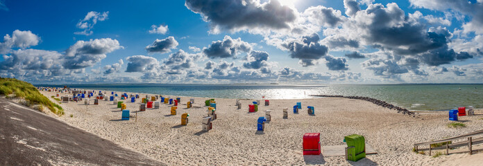 Panoramablick über den menschenleeren Strand von Utersum auf der Nordseeinsle Föhr mit Strandkörben bei aufgelockerter Bewölkung © Frank Wagner