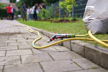 Watering hose with tap on the territory for landscaping.