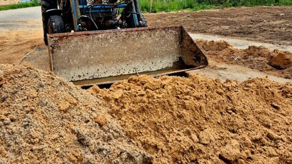 Heavy Machinery Working on Road Construction With Sand and Gravel in a Rural Setting