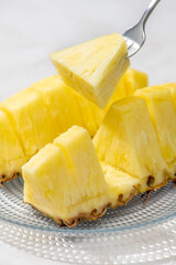 カットしたパイナップルをフォークでさして食べる