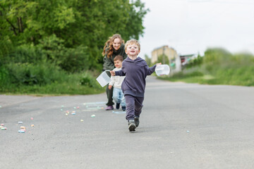 Fototapeta premium Happy Child Running with Containers Outdoors