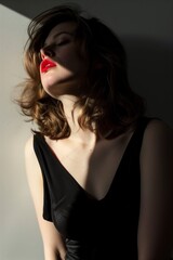 Fototapeta premium Portrait of a beautiful woman with red lips in a black dress