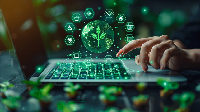 A hand engages with a laptop, generating a holographic display of eco-friendly icons and a leaf symbol, representing sustainable technology and green computing initiatives.