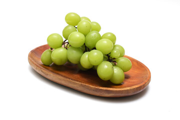 白背景の木製の皿にのせたマスカット
