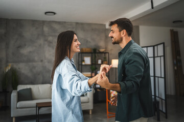 Adult cheerful couple boyfriend and girlfriend dance at home