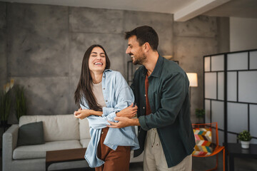 Adult cheerful couple boyfriend and girlfriend dance at home
