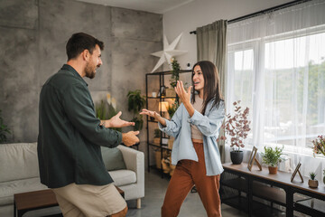 Adult cheerful couple boyfriend and girlfriend dance at home