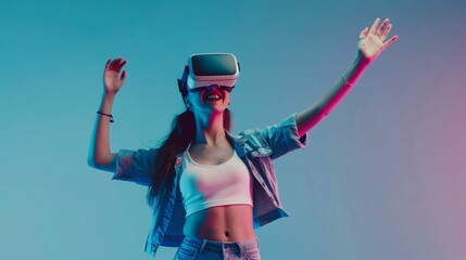 Cheerful young woman trying new visual reality headset posing and dancing on trendy blue background, concept of attraction of vr equipment, new technology to the market.