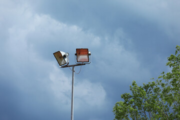 Street floodlight against blue sky. Street lighting
