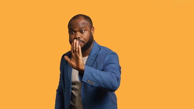 Stern african american man doing stop hand gesture sign. Annoyed BIPOC person doing firm halt sign gesturing, wishing to end concept, isolated over studio background, camera A