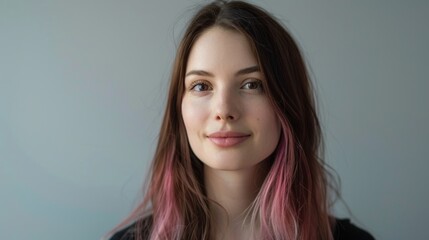 Fototapeta premium Portrait of a serene young woman with long hair and subtle pink highlights. Close-up shot with soft light, ideal for lifestyle and beauty themes. Conceptualizes calm and confidence. AI