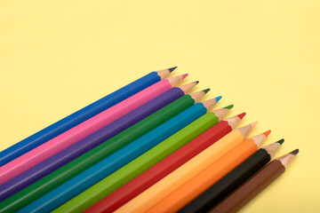 Fototapeta premium Colored pencils on yellow background