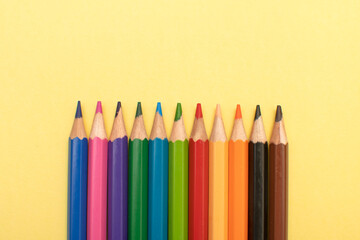 Colored pencils on yellow background