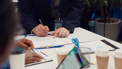 Entrepreneurs signing a new partnership contract between their firms, joining forces to capitalize...