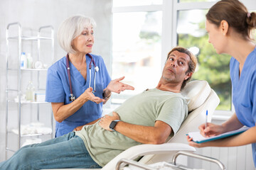 Obraz premium Gastroenterologist doctor consulting man in clinic. Patient having medical exam with doctor on illness from stomach discomfort.