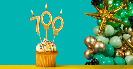 Birthday candle number 700 - Cupcake with decoration on a green background