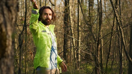 Rescue squad leader guiding route through the woods to collect evidence during searching operation to locate missing person. Shouting individual's name, civil disappeared in a forest. Camera A.