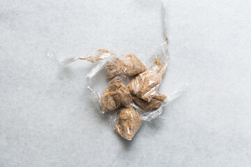 Overhead view of ground dried crayfish in transparent cellophanes, top view of dried shrimp powder, flatlay of nigerian crayfish powder on a white background