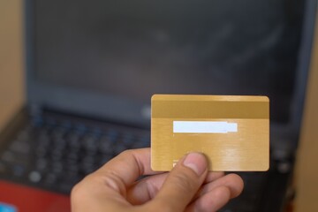 Man's hands holding a credit card and using laptop for online shopping, Online payment, Top view, screen mockup for display.