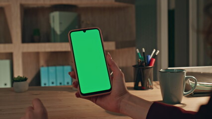 Businesswoman tapping smartphone green screen at video call in office close up.