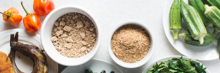 Overhead view of ingredients for making ogbono soup on a granite countertop, top view of mise en place of ingredients for making ogbono and okro soup, process of making nigerian ogbono soup