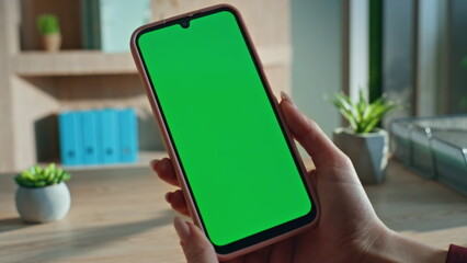 Girl hands holding chroma key cellphone at workplace closeup. Unknown woman