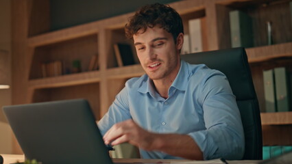 Creative startuper working laptop at evening apartment close up. Smiling man 