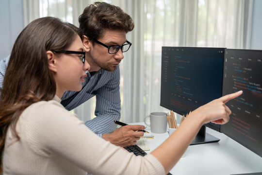 Team skilled developers program thinking newest coding creative website planning software project on two pc screen, comparing with typing full stack data analyzing prompt design at office. Postulate.