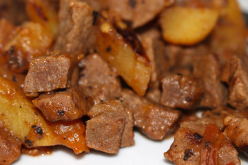 meat with potatoes and tomatoes. stew of meat, potatoes and tomatoes. food with selective focus. meal details.