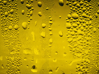 Drops of ice on a yellow drinking glass