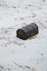 Small treasure chest and fake gold coins on the beach in Albany Western Australia