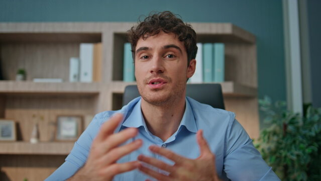 Pov entrepreneur talking camera interview in office. Online coach waving hand